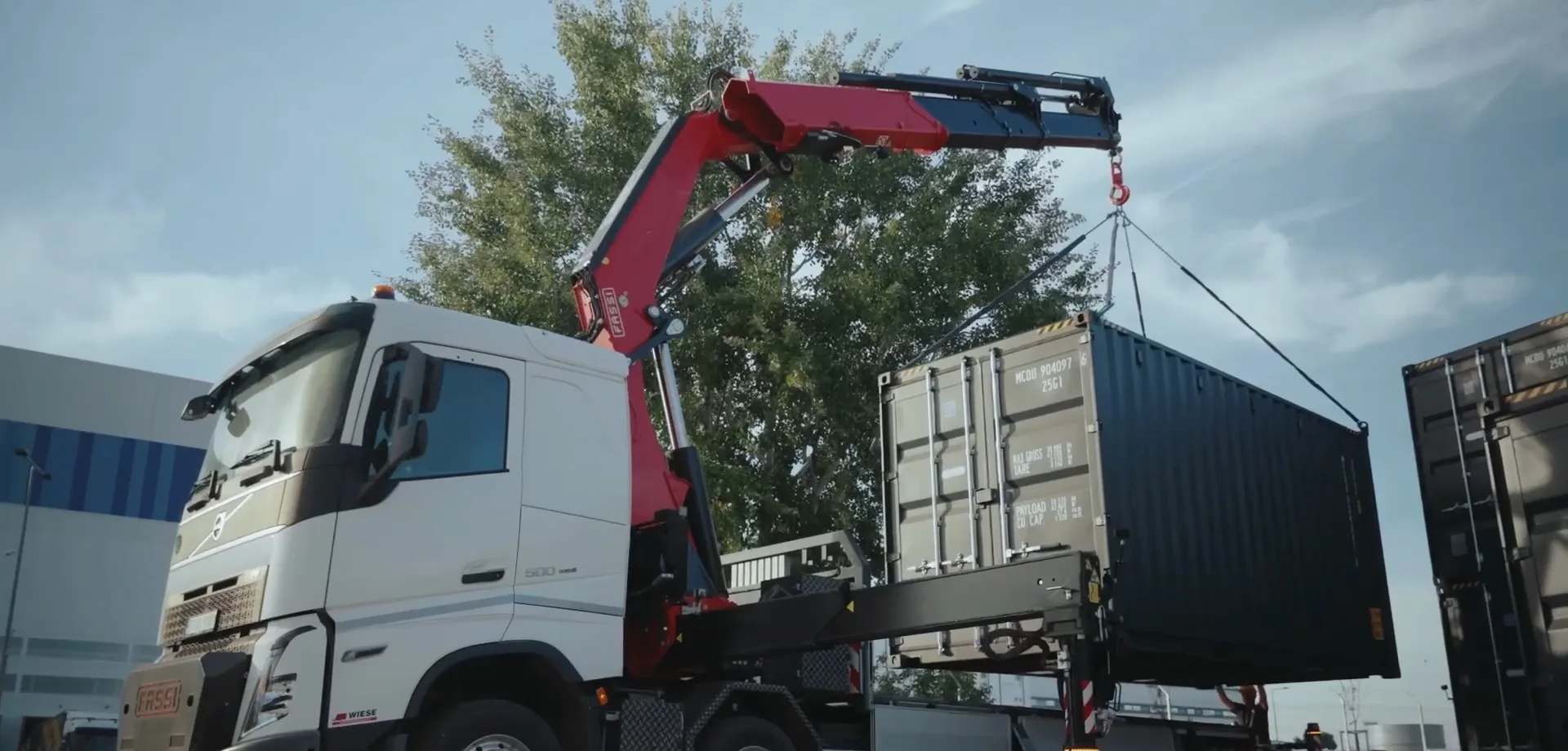 A truck-mounted crane lifting a Sonic Pod container onto a site, from the Runware factory film