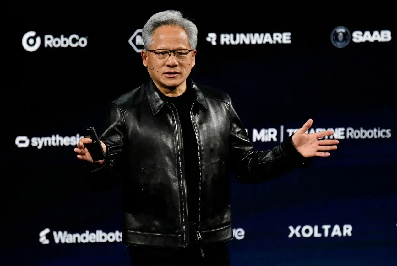 NVIDIA CEO Jensen Huang on stage at GTC Berlin, with the Runware logo among the partner logos behind him
