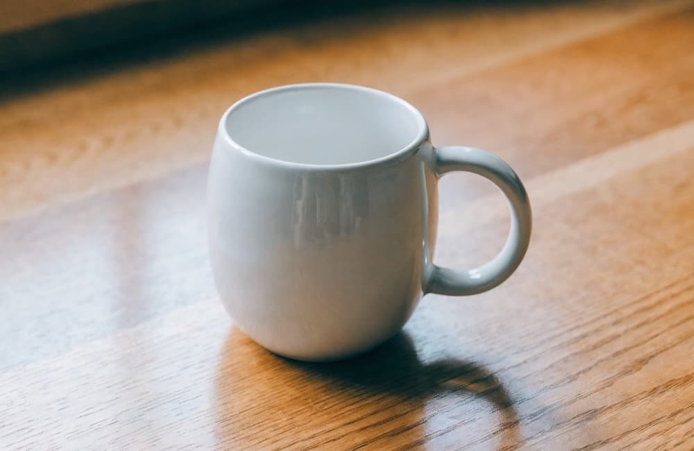 Enhanced product photography prompt output from Qwen3.5 27B — ceramic mug on wooden table