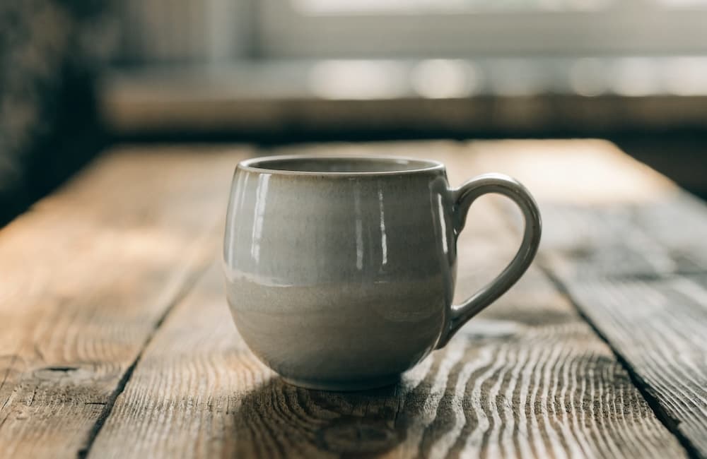 Enhanced product photography prompt output from GLM-4.7 — ceramic mug on wooden table