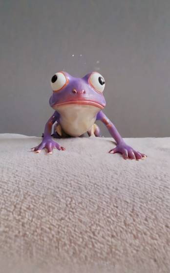 A purple frog sitting on top of a white surface