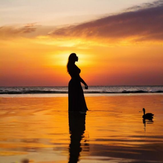 A woman standing in the water with a bird flying above her head