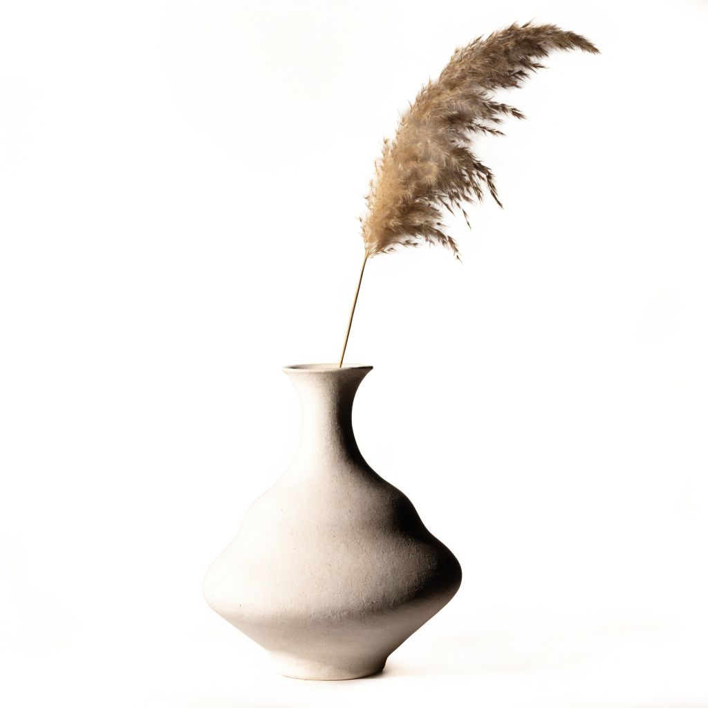 A minimalist ceramic vase on a pure white background