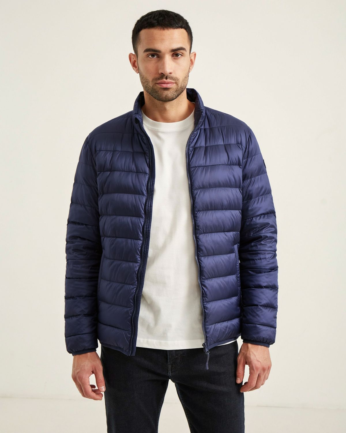 The same man and pose with the puffer jacket in dark navy blue