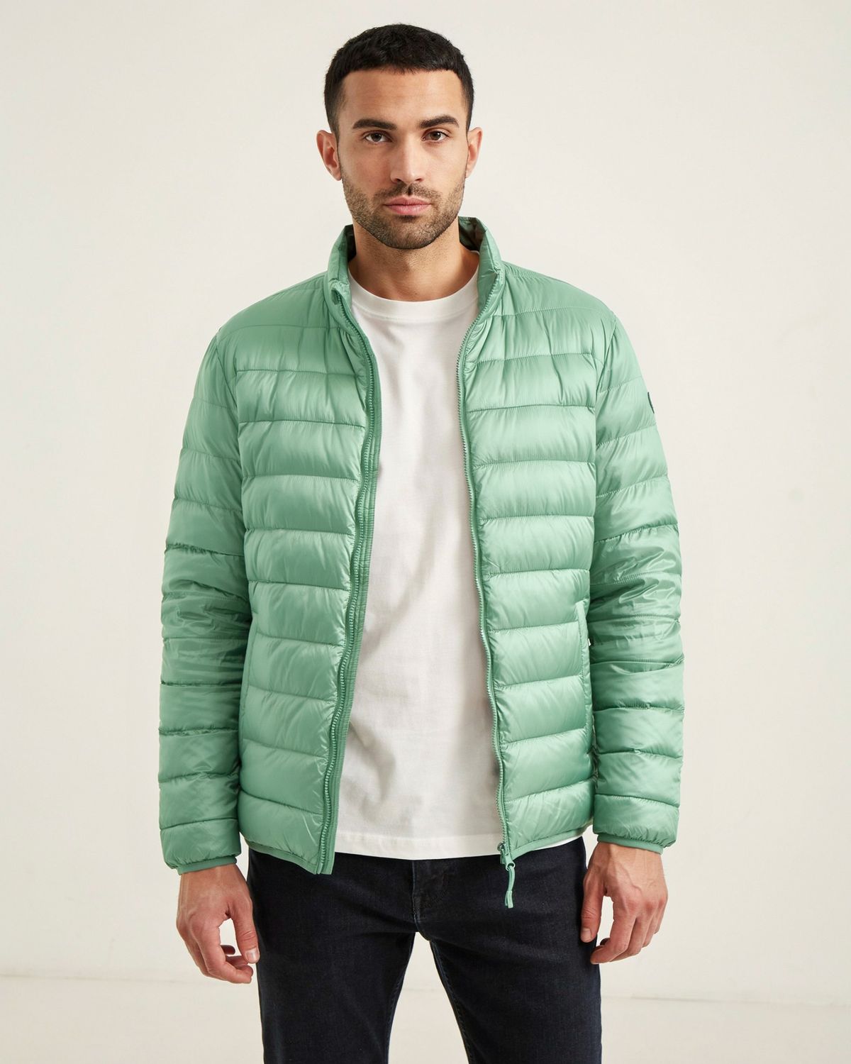 The same man and pose with the puffer jacket in soft sage green