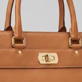 A soft, blocky close-up crop of the handbag clasp and top-stitching