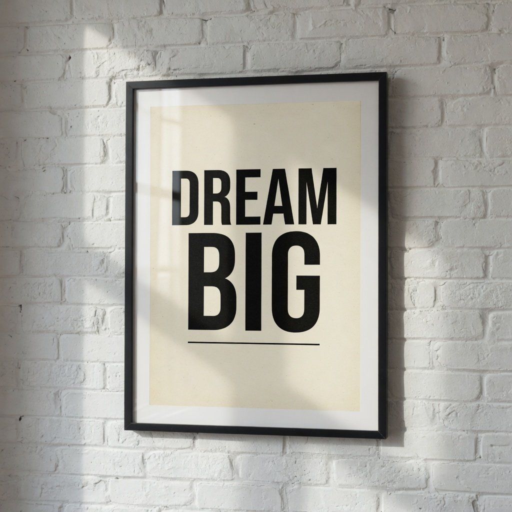 A framed motivational poster on a white brick wall reading DREAM BIG in bold black letters