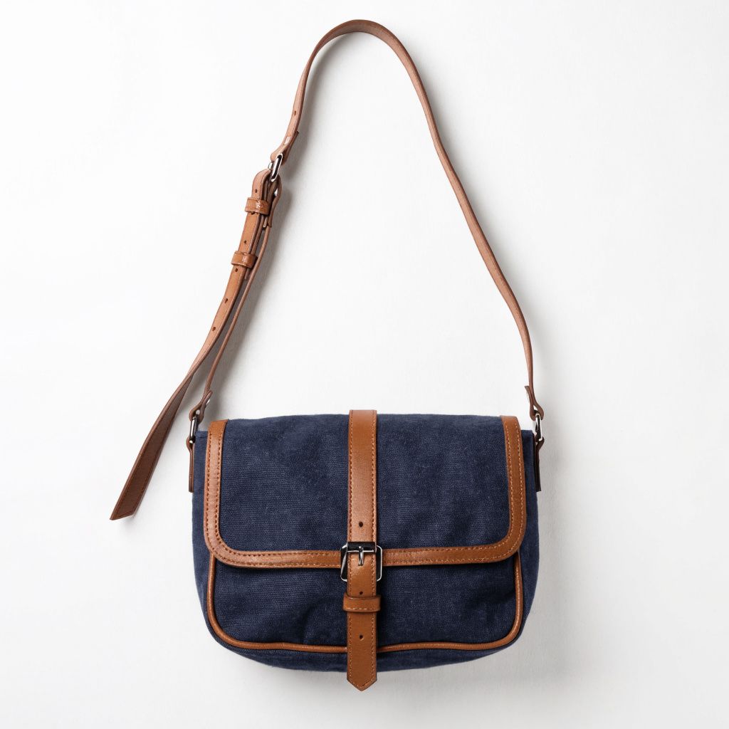 A navy canvas crossbody messenger bag