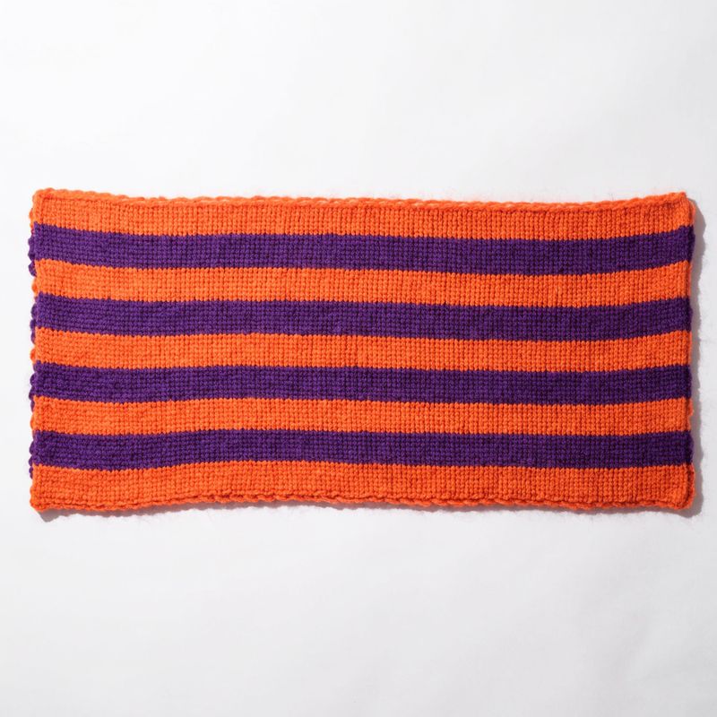 An orange and purple striped knit scarf