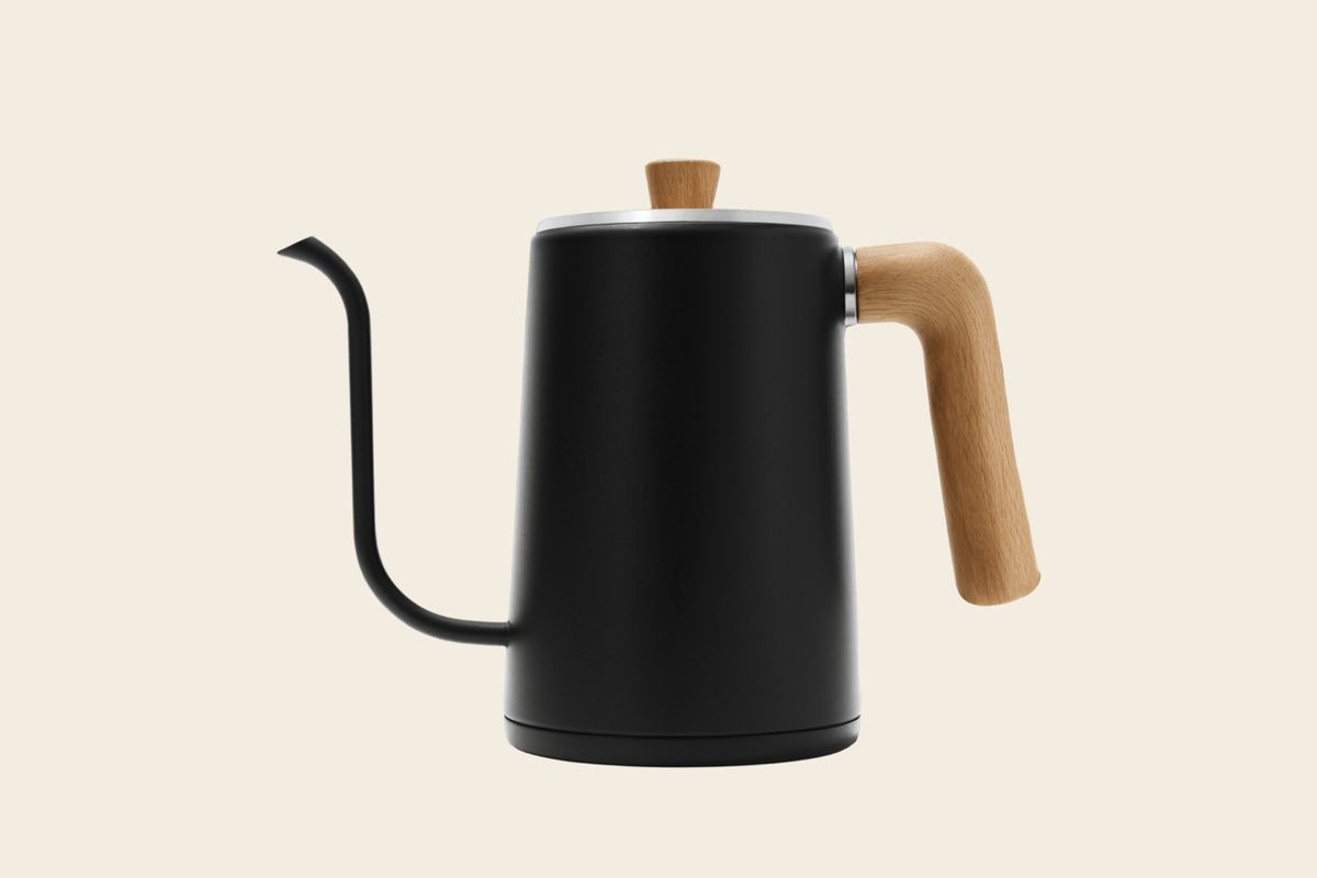 The matte black kettle cut-out placed on a plain warm cream background