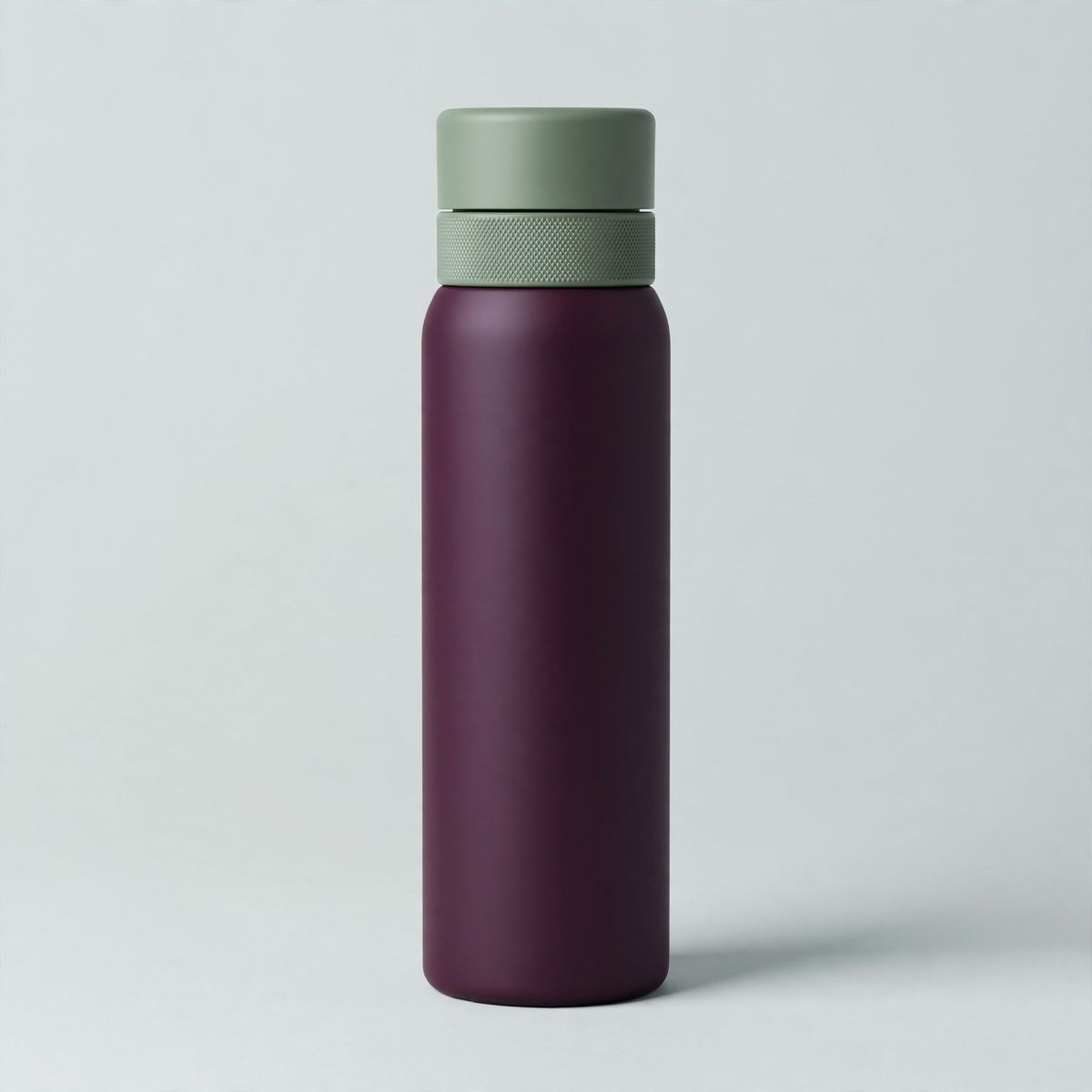 A matte deep-aubergine insulated water bottle with a sage-green lid and knurled collar standing centred on a seamless pale grey backdrop under soft top light