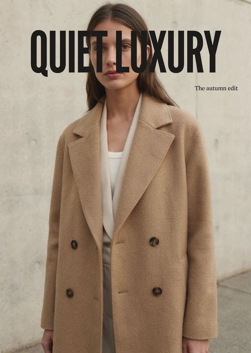 A fashion ad of a model in a camel coat against concrete, with QUIET LUXURY and The autumn edit set in the upper space