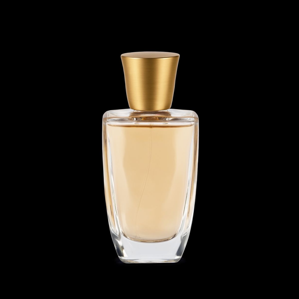 A clear glass perfume bottle with pale amber liquid and a brushed gold cap, cut out with no background behind it