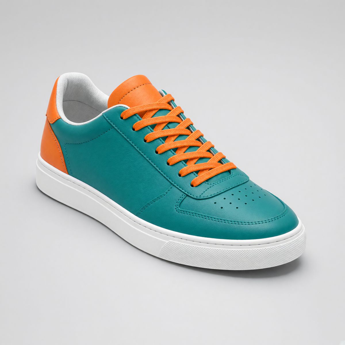 The same sneaker recoloured into a teal upper with orange accents, the white sole, background, and framing unchanged