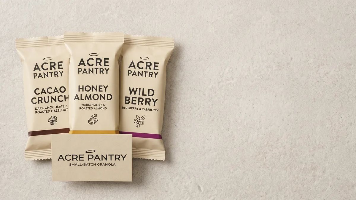 A 16:9 wide banner of the Acre Pantry bars anchored on one side of the frame with the other side left as generous negative copy space for an email subject line and CTA overlay