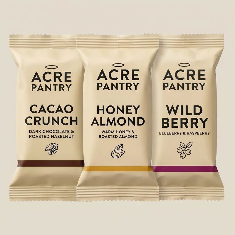 A square 1:1 product tile of the three Acre Pantry bars laid out for an e-commerce product grid with the bars dominating the frame and a clean pale background