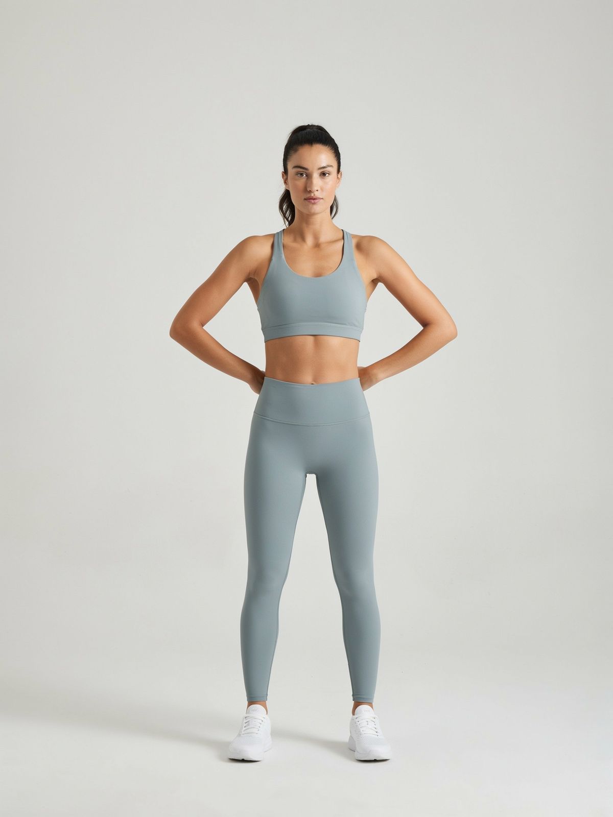 The same woman standing with both hands on her hips