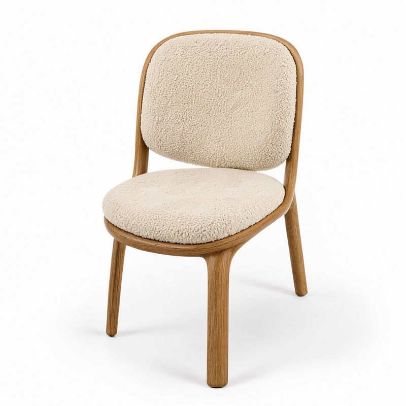 A lounge chair with a curved oak frame and cream boucle cushions on a white background