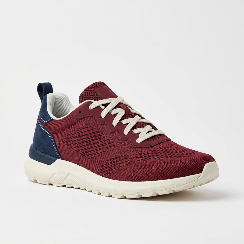 A studio product photo of a burgundy mesh running shoe with a navy heel panel, cream rubber sole and flat cream laces on a white background