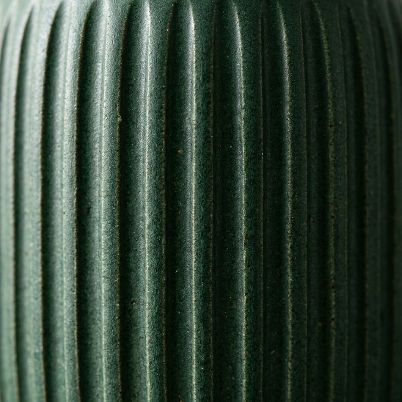 A close photo of the forest green vase's surface filling the frame, showing its vertical ribbed texture and matte glaze
