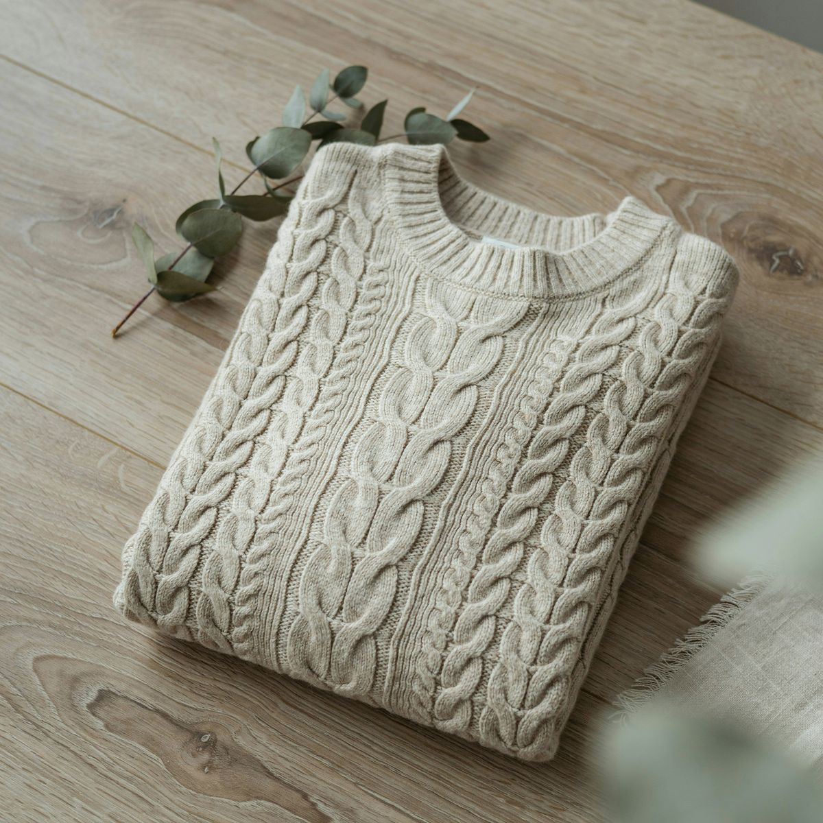 The same sweater at 2K, with a magnified inset showing individual wool fibers in the cable pattern
