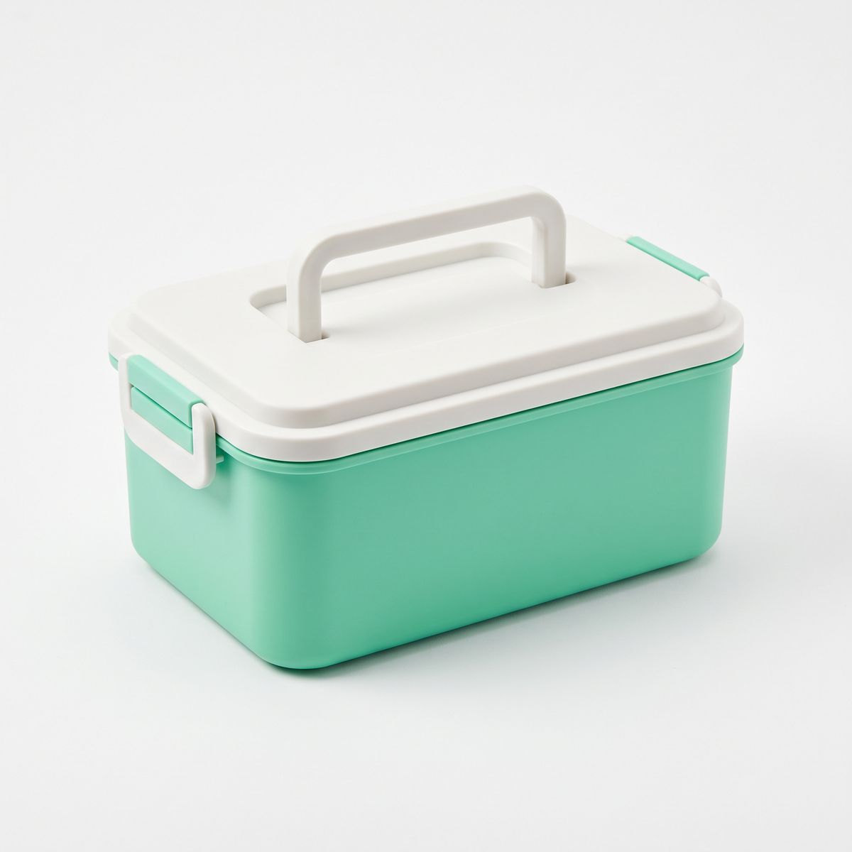 A mint green lunch box with a white lid and handle on white