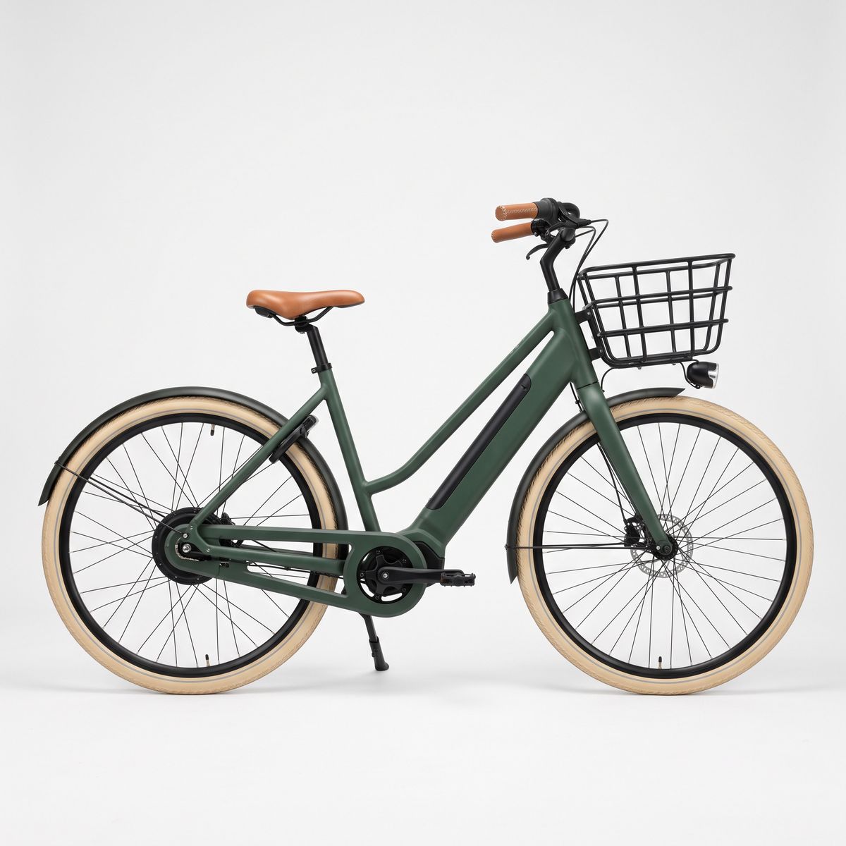 A matte forest green step-through e-bike with a tan leather saddle and grips, a black front basket, and cream tires in side profile on white