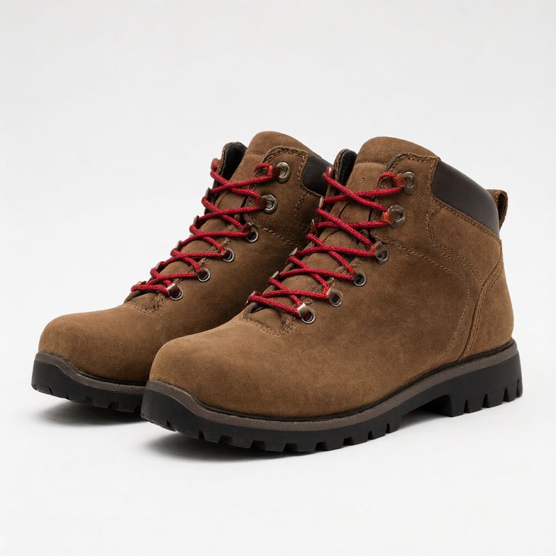 A pair of brown suede hiking boots with red laces and black soles on white