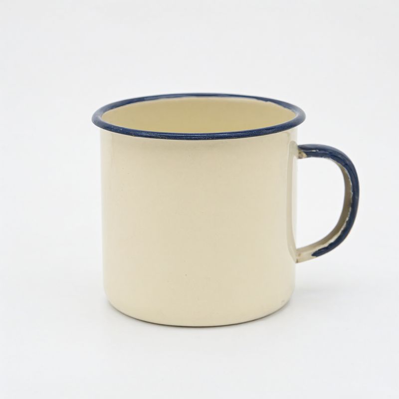 A cream enamel camping mug with a dark blue rim on white