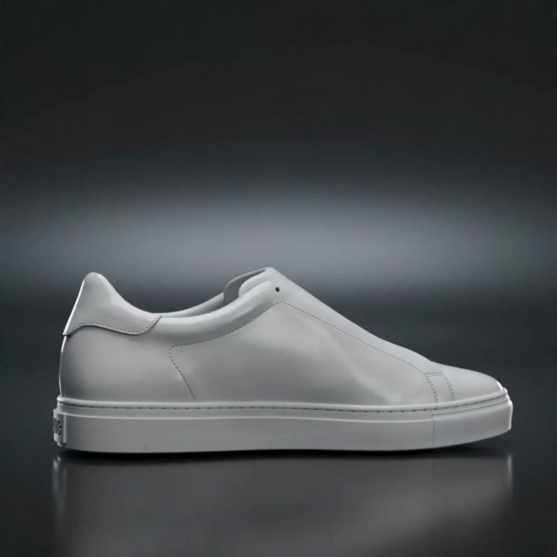 First frame extracted from the source clip: a plain white leather sneaker on a black matte surface, no markings