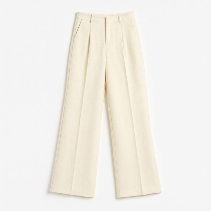 High-waisted cream wool wide-leg pleated trousers laid flat on white